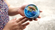 Thai Union Manufacturingin (TUM) työntekijä pitää kadessään Thai Unionin valmistamaa tonnikalapurkkia. Kuva: Finnwatch.
